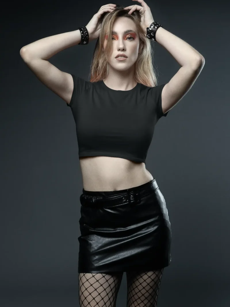 Female model wearing M4S Solids Black Baby Tee in a studio 1