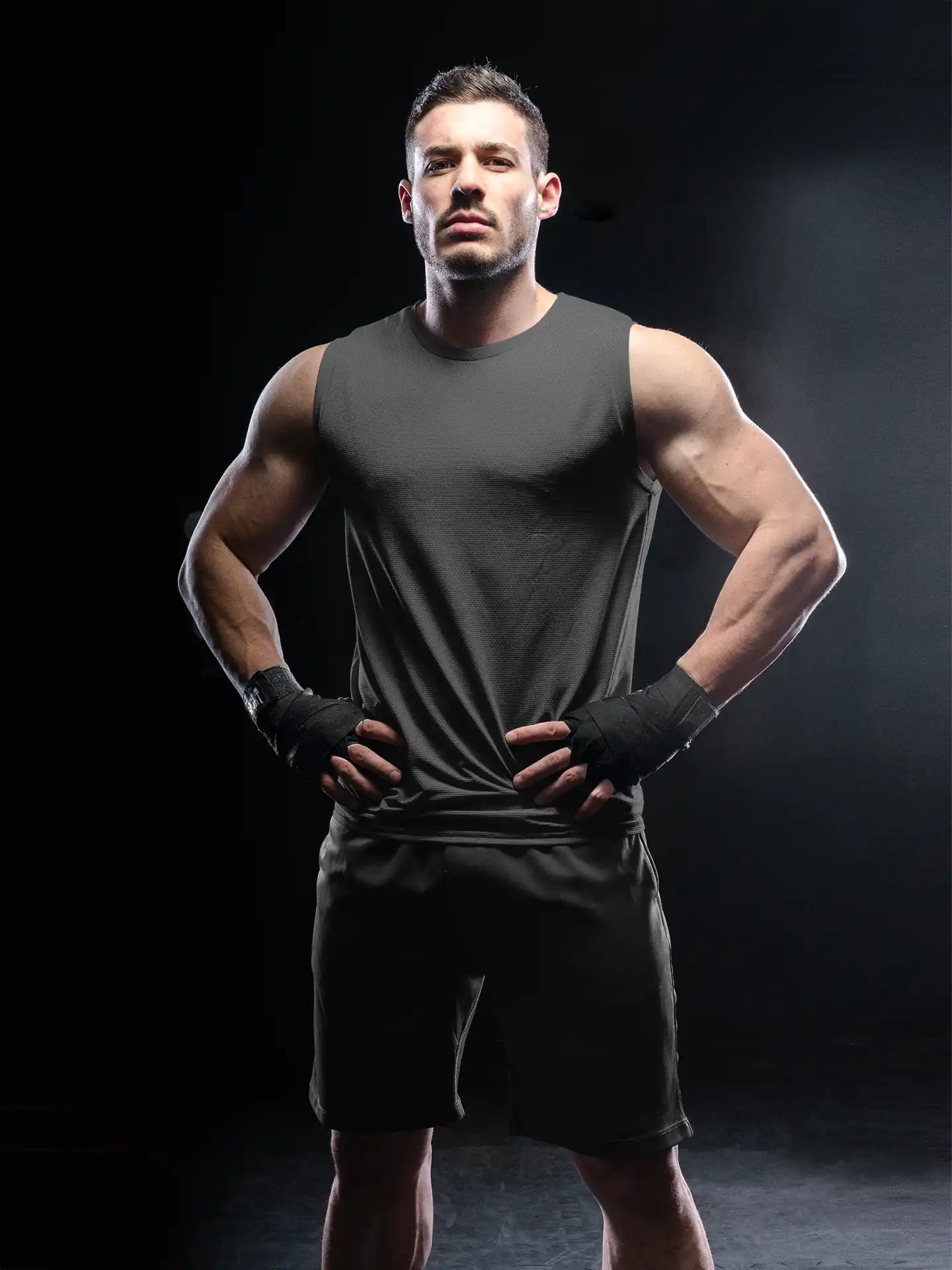 Man wearing M4S Solids Male Black Sleeveless Tee in a studio Man wearing M4S Solids Male Black Sleeveless Tee in a studio