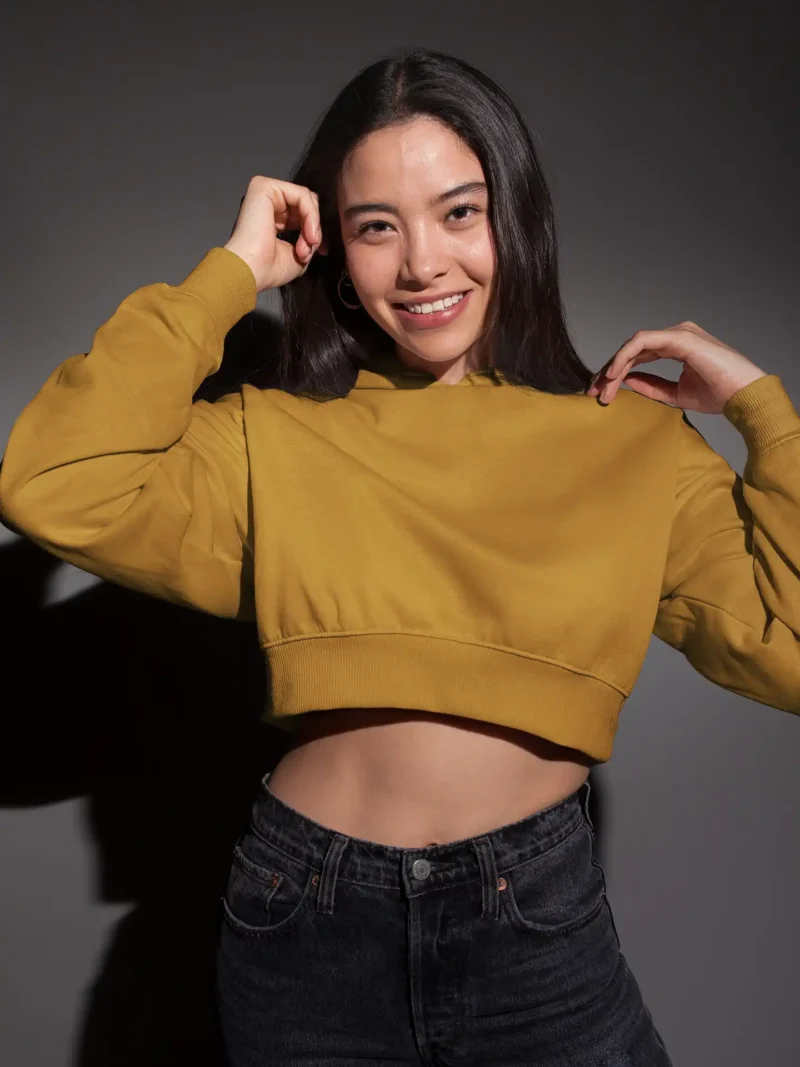 Woman wearing M4S Solids Mustard Yellow Cropped Hoodie in a studio 1