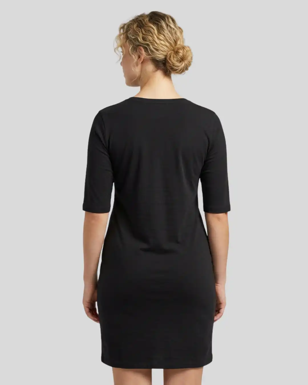 Back shot of Female model wearing M4S Solids Black T-Shirt Dress in a studio Back shot of Female model wearing M4S Solids Black T-Shirt Dress in a studio