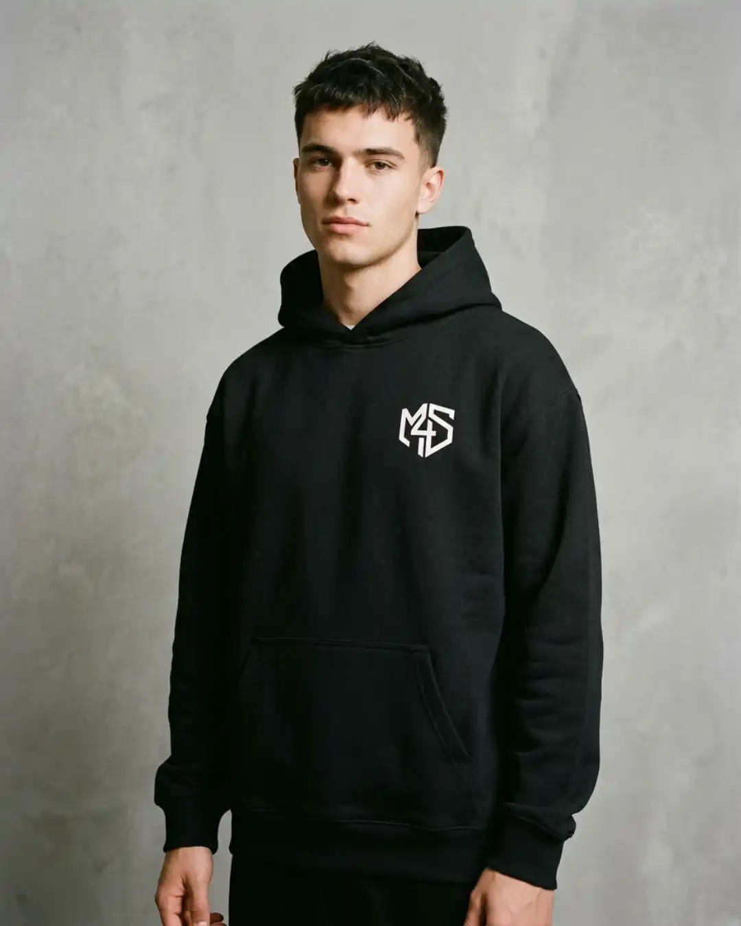 Off Autopilot Hoodie – Wear – Male Male model wearing the black Off Autopilot Hoodie in a minimalist concrete setting