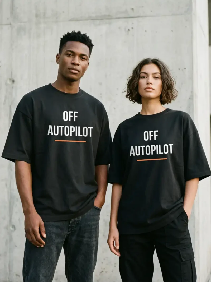 Male and female models wearing the black Off Autopilot Oversized Tee in an urban setting