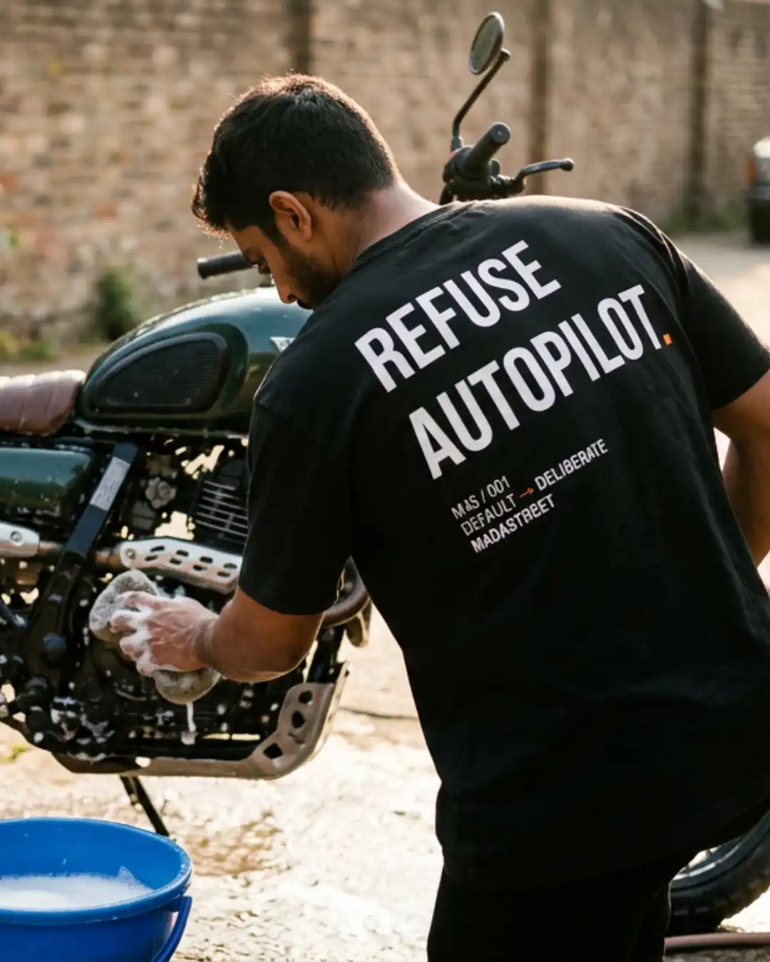 Refuse Autopilot Heavyweight Oversized Tee – Motorcycle Lifestyle Male wearing the Refuse Autopilot Heavyweight Oversized Tee while working on a motorcycle outdoors